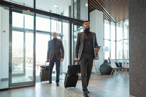 Két Elegáns Üzleti Utazók Húzza Bőröndök Miközben Belép Hotel Lounge — Stock Fotó