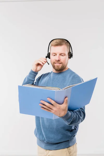 Heureux Jeune Opérateur Dans Casque Regardant Des Documents Dans Dossier — Photo