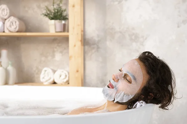 Hombre Joven Sereno Relajado Con Máscara Facial Disfrutando Baño Caliente —  Fotos de Stock