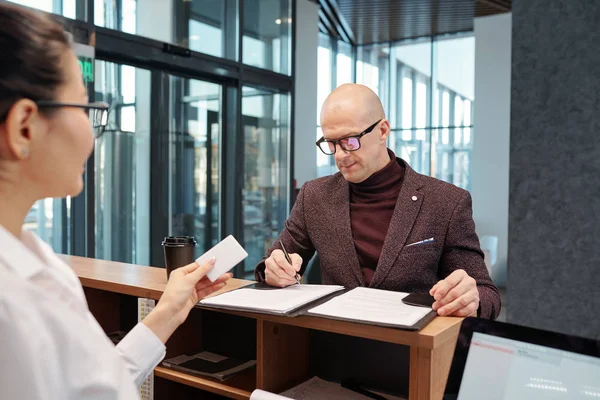 Bald Confident Businessman Filling Form Counter Front Receptionist Arriving Hotel — Stockfoto