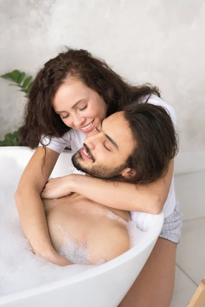 Šťastná Mladá Láskyplná Žena Objímající Svého Uvolněného Manžela Těší Koupel — Stock fotografie