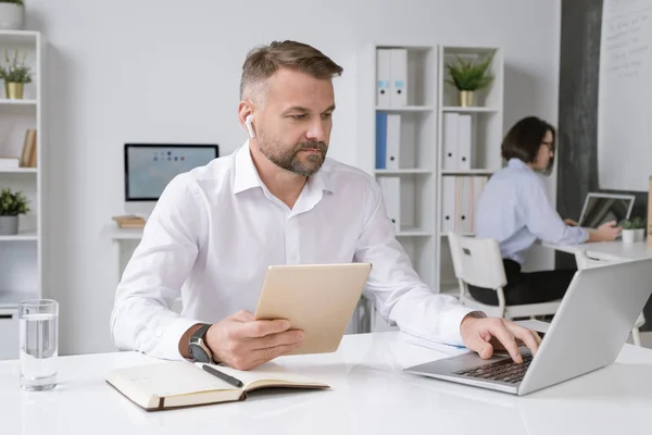 Empresário Confiante Com Tablet Sentado Mesa Frente Laptop Preparando Apresentação — Fotografia de Stock