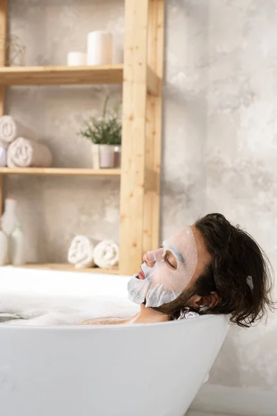 Hombre Joven Relajado Que Tiene Mascarilla Mientras Está Acostado Baño — Foto de Stock