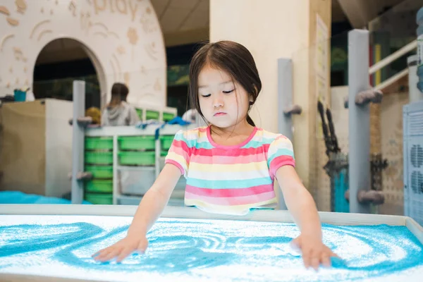 アジアの民族のかわいい女の子は彼女の手で青砂の写真を作りながら 子供部屋で時間を過ごす — ストック写真