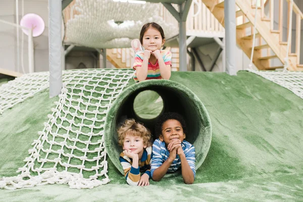 Przyjazne Międzykulturowe Dzieci Odpoczywające Placu Zabaw Spędzając Czas Współczesnym Ośrodku — Zdjęcie stockowe