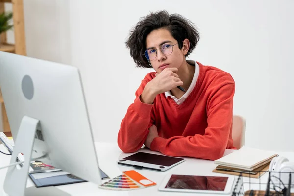 Pensive Mannelijke Freelancer Casualwear Bril Kijken Naar Terwijl Zitten Voorkant — Stockfoto