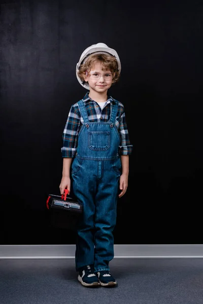 Menino Adorável Hardhat Macacão Jeans Óculos Segurando Caixa Ferramentas Enquanto — Fotografia de Stock