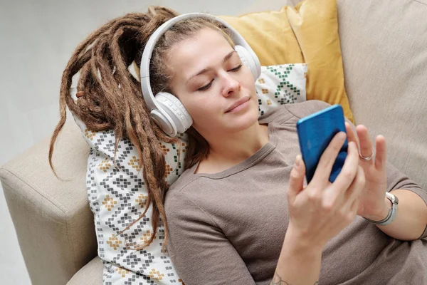 Pretty Young Restful Woman Dreadlocks Listening Music Headphones Scrolling Smartphone — Stock Photo, Image