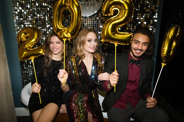 Três Jovens Amigos Traje Glamouroso Segurando Números Infláveis Ouro Ano — Fotografia de Stock