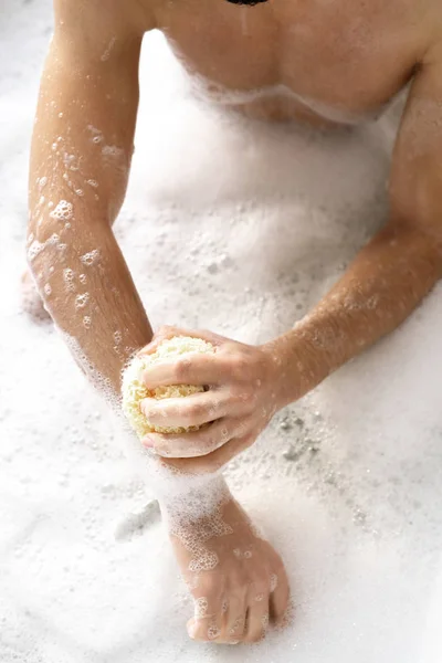 Przegląd Młody Człowiek Bez Koszuli Gąbką Myje Ręce Siedząc Wannie — Zdjęcie stockowe