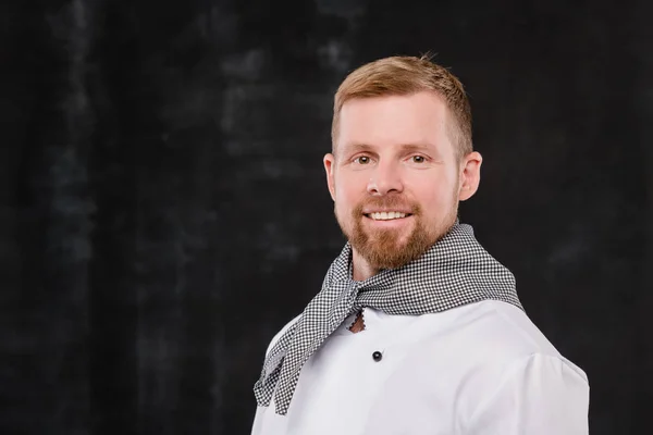 Joven Chef Sonriente Uniforme Mirándote Mientras Está Pie Sobre Fondo —  Fotos de Stock