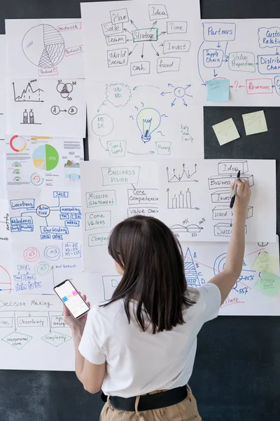 Rückansicht Einer Trainerin Mit Smartphone Die Auf Finanzinformationen Auf Papieren — Stockfoto