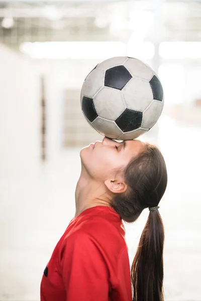 Mladá Fotbalistka Červeném Tričku Drží Fotbalový Míč Čele Nosu Při — Stock fotografie