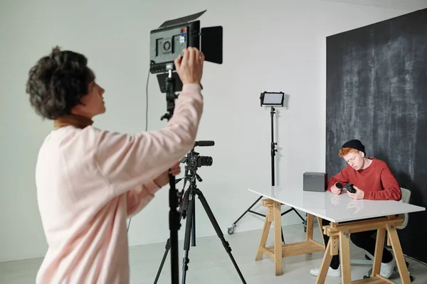 Mladý Muž Casualwear Připravuje Videokameru Před Natáčením Zatímco Stojí Studiu — Stock fotografie