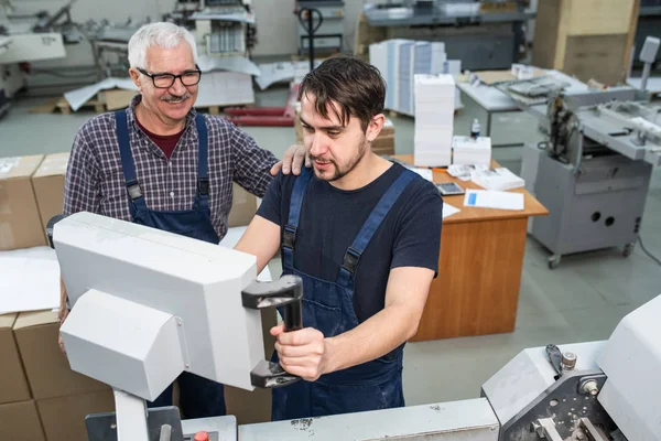 공장에서 인쇄기를 점검하는 직장인을 지원하는 — 스톡 사진