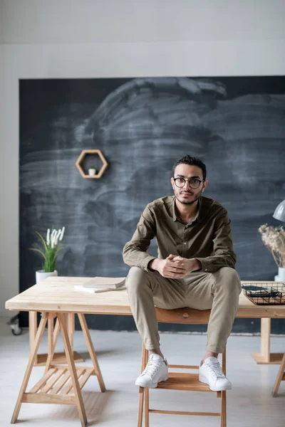 Empresário Sério Casualwear Óculos Olhando Para Você Enquanto Sentado Mesa — Fotografia de Stock