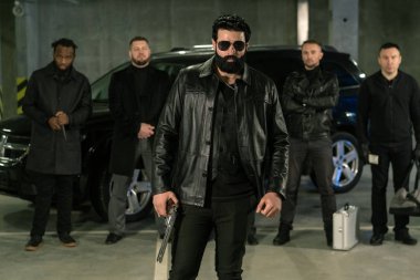 Güneş gözlüklü, siyah deri ceketli ve geçmişinde çetesi olan kot pantolonlu bir suçlu.