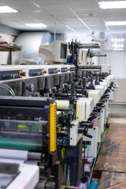 Fabrikadaki bilgisayar monitörüyle güçlü baskı makinesinin yan görüntüsü