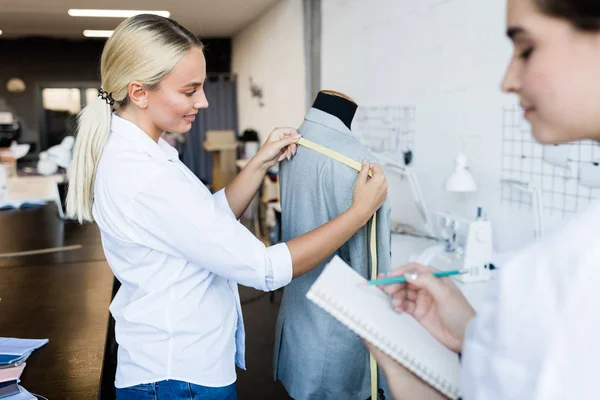 Smiling Attractive Young Woman Measuring Jacket While Making Individual Order — Foto de Stock