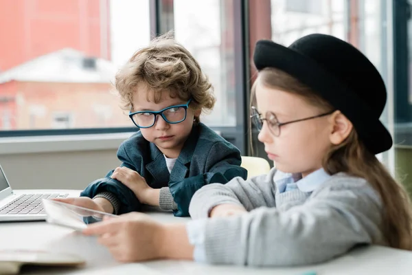 Masa Başında Sunum Hazırlarken Şapkalı Sınıf Arkadaşına Bakan Gözlüklü Ciddi — Stok fotoğraf
