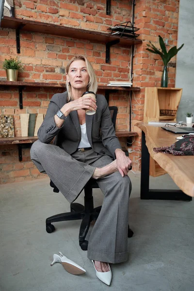 Kontemplativ Mogen Affärskvinna Grå Kostym Hålla Bara Foten Andra Benet — Stockfoto