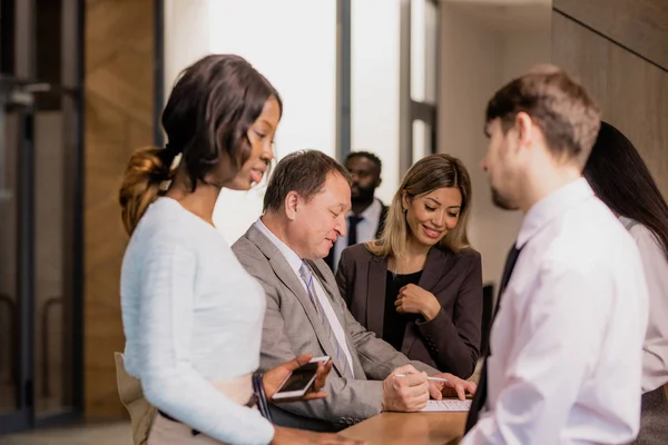 Grupo Empresarios Contemporáneos Diversas Etnias Edades Comunicadas Por Mostrador Recepción — Foto de Stock