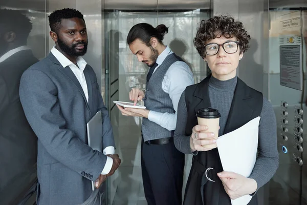 Jovem Empresária Pensiva Com Copo Café Papel Movendo Elevador Com — Fotografia de Stock