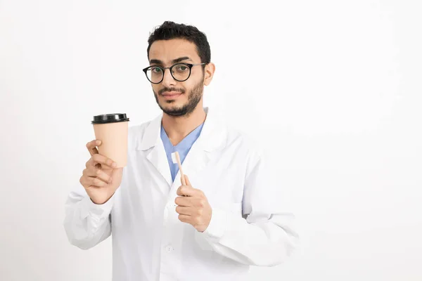 Νεαρός Οδοντίατρος Λευκή Ρόμπα Και Γυαλιά Που Κρατάει Ένα Ποτήρι — Φωτογραφία Αρχείου