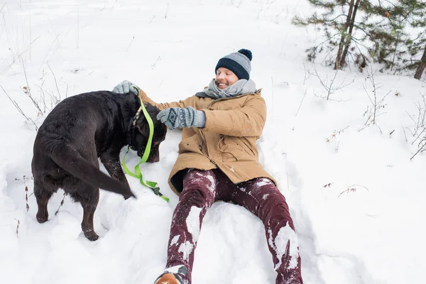 Glädjande Kille Vinterkläder Kul Medan Leker Med Svart Retriever Snö — Stockfoto