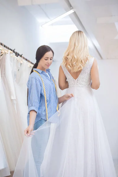 Content Young Dressmaker Adjusting Hem Wedding Dress Gown Fitting Studio — 스톡 사진