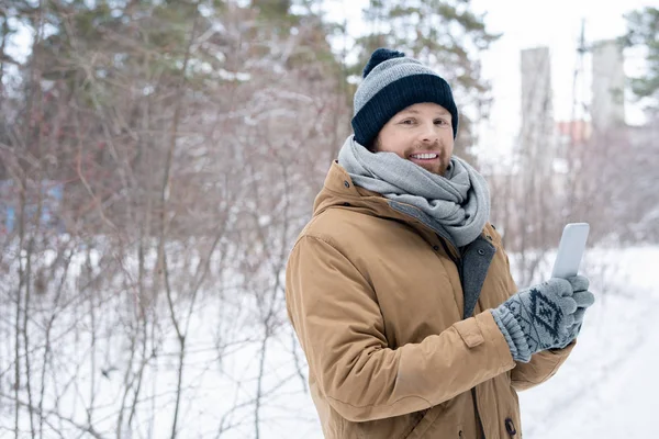 Glad Ung Man Varma Vinterkläder Håller Smartphone Framför Sig Själv — Stockfoto