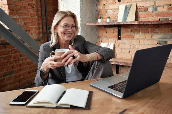 Gülümseyen Olgun Kadını Kahve Içiyor Internette Arkadaşıyla Iletişim Kurarken Dizüstü — Stok fotoğraf
