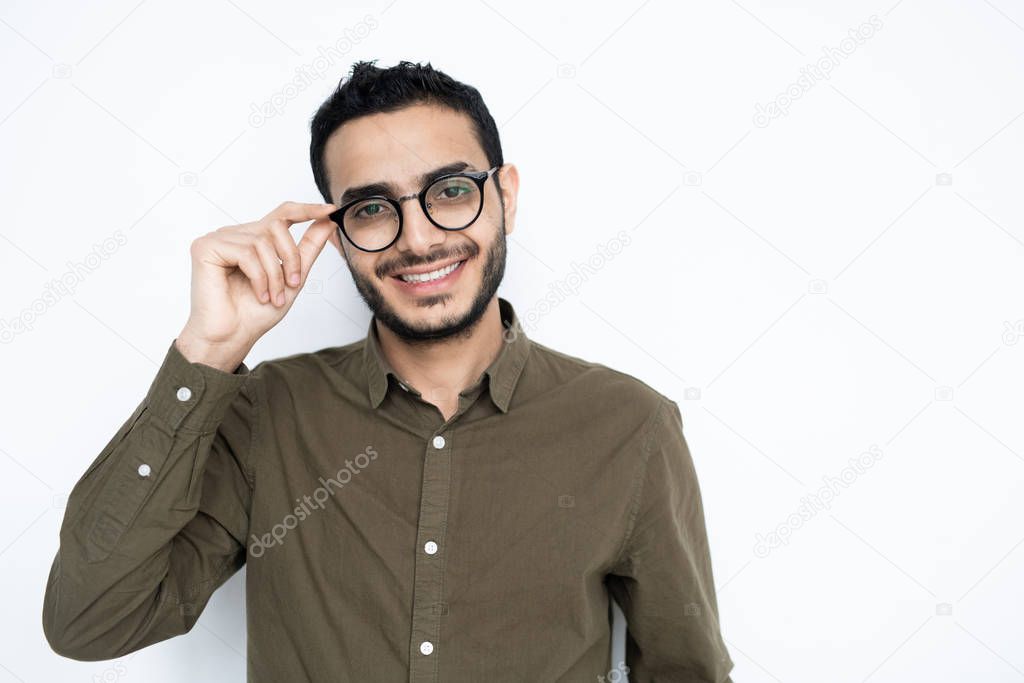 Happy guy with nice toothy smile looking at you through eyeglasses while standing in isolation on white background