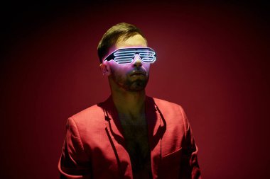 Masada gözleri kapalı oturan ve kulaklıkla ilham verici müzikler dinleyen sakallı, rahat genç bir adam.