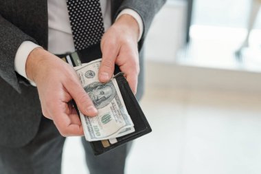 Takım elbiseli tanınmayan işadamlarının yakın plan fotoğrafları. Kredi ve indirim kartlarıyla cüzdanlarından para alıyorlar.