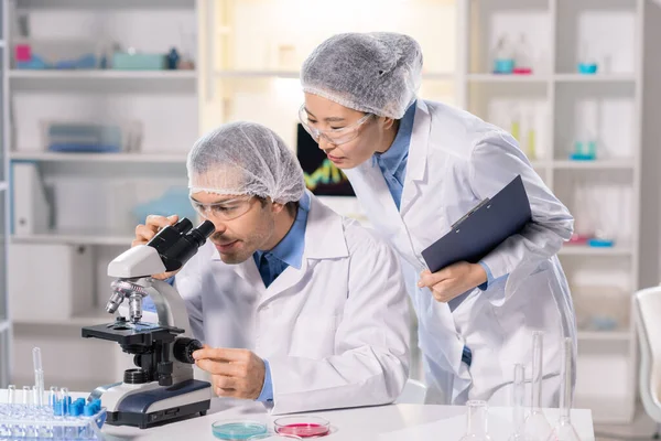 Focused Scientist Safety Goggles Using Microscope While Working Medical Research — Zdjęcie stockowe