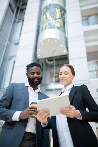 Debajo Vista Jóvenes Colegas Interraciales Usando Tableta Digital Mientras Analizan — Foto de Stock