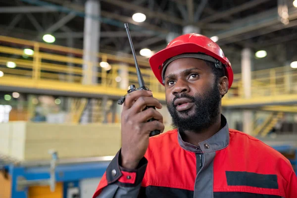 Young Bearded Black Laborer Red Uniform Transferring Message Coworker Walkie — Stockfoto