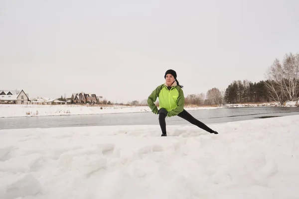 Ceketli Genç Atletik Kadın Kış Sahilinde Antrenman Yaparken Kara Atlıyor — Stok fotoğraf