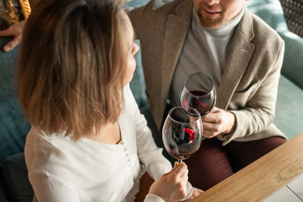 在餐馆里 男人和女人坠入爱河时 在酒杯与红酒的碰撞下拍下的高角水平线照片 — 图库照片