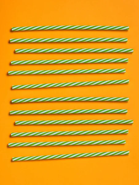Grön Och Vit Randig Plast Dryckessugrör Ljus Orange Bakgrund Vertikal — Stockfoto