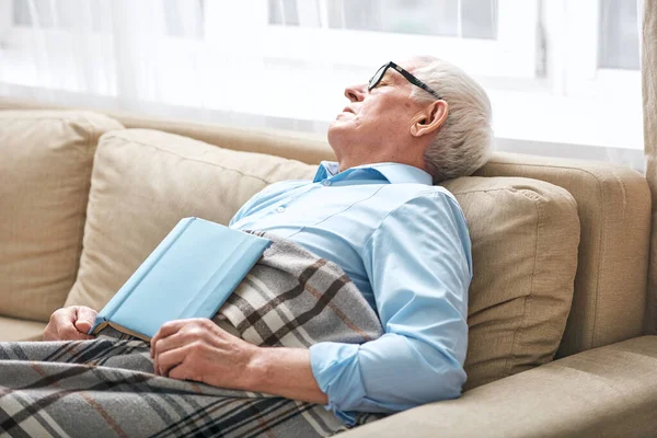 Hombre Mayor Cansado Cubierto Con Siesta Cuadros Sofá Con Libro — Foto de Stock