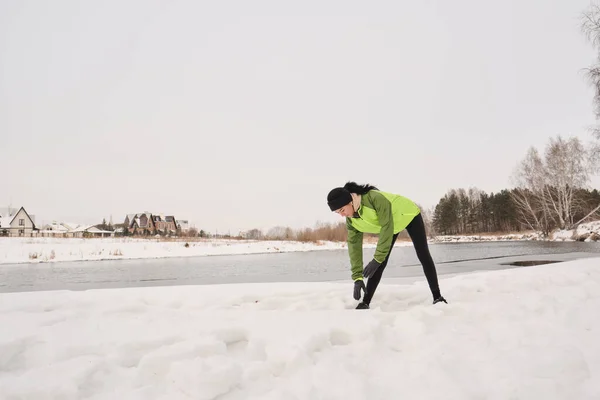 Young Woman Green Jacket Standing Winter Lake Bending While Doing — Stock Photo, Image