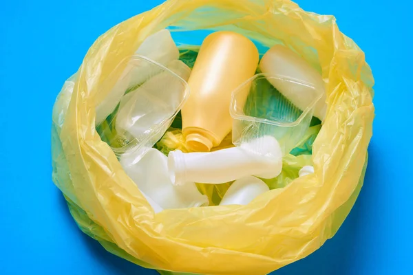 Горизонтальний Зверху Знімок Жовтого Пластикового Мішка Пластиковим Сміттям Синій Поверхні — стокове фото