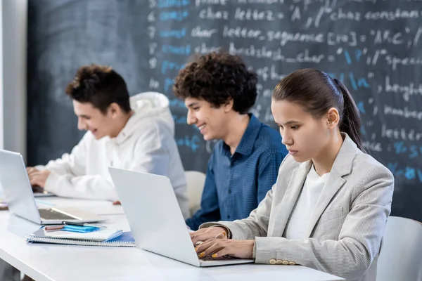 Fila Jovens Estudantes Universitários Contemporâneos Cooperando Por Escrivaninha Frente Laptops — Fotografia de Stock