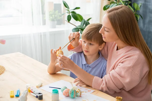 Young Mother Sitting Table Paint Cans Adding Paint Sons Easter — Stock Photo, Image