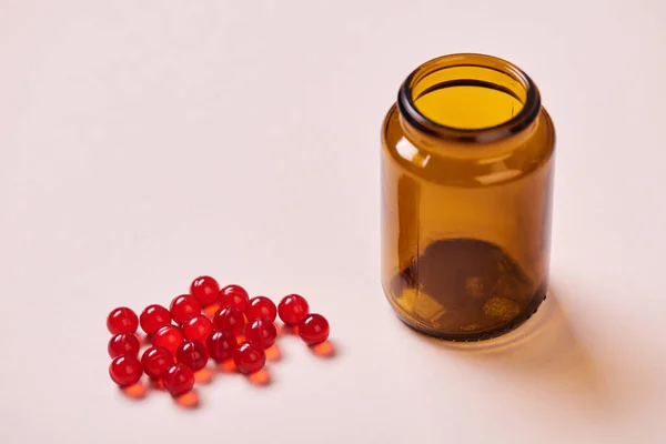 Barna Üvegvitaminos Palack Vörös Vitaminos Gyógyszerek Halvány Rózsaszín Felületen Vízszintes — Stock Fotó