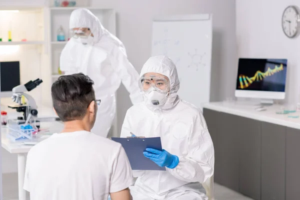 Clinical Researcher Protective Suit Making Notes Clipboard While Talking Infected — ストック写真