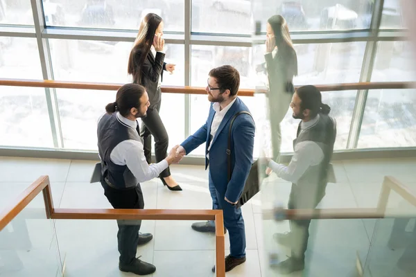 オフィスセンターの廊下で握手をするコンテンツビジネスマン 彼らは新しいパートナーシップを構築します — ストック写真