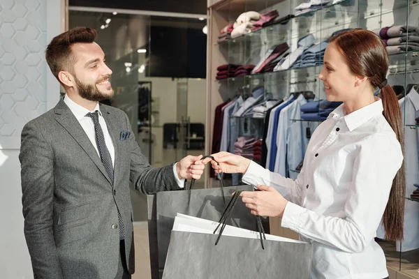 Vänlig Ung Säljare Kläder Butik Ger Shoppingväskor Till Nöjda Manliga — Stockfoto